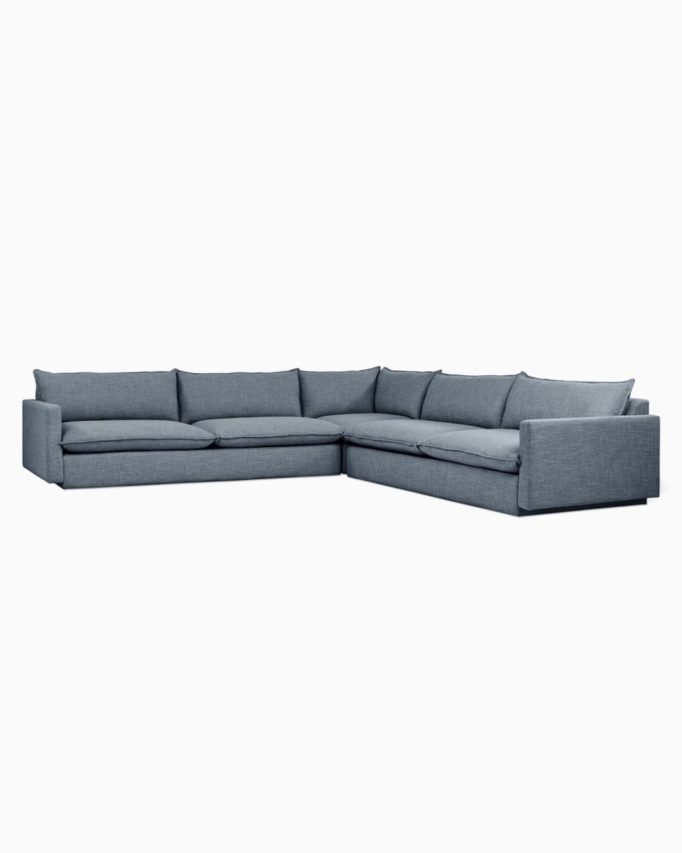 Gray L-shaped sectional sofa with six pillows and straight legs.
