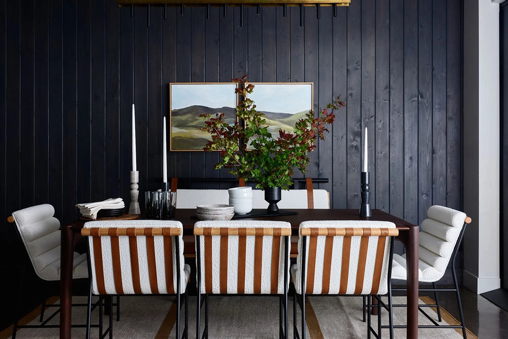 Dining room with a dark wall, table, Vail Dining Chairs, and decorative elements.
